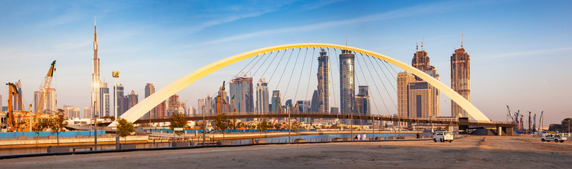 Colorful Sunset Over Dubai Downtown Skyscrapers And The Newly Built Tolerance Bridge As Viewed From The Dubai Water Canal